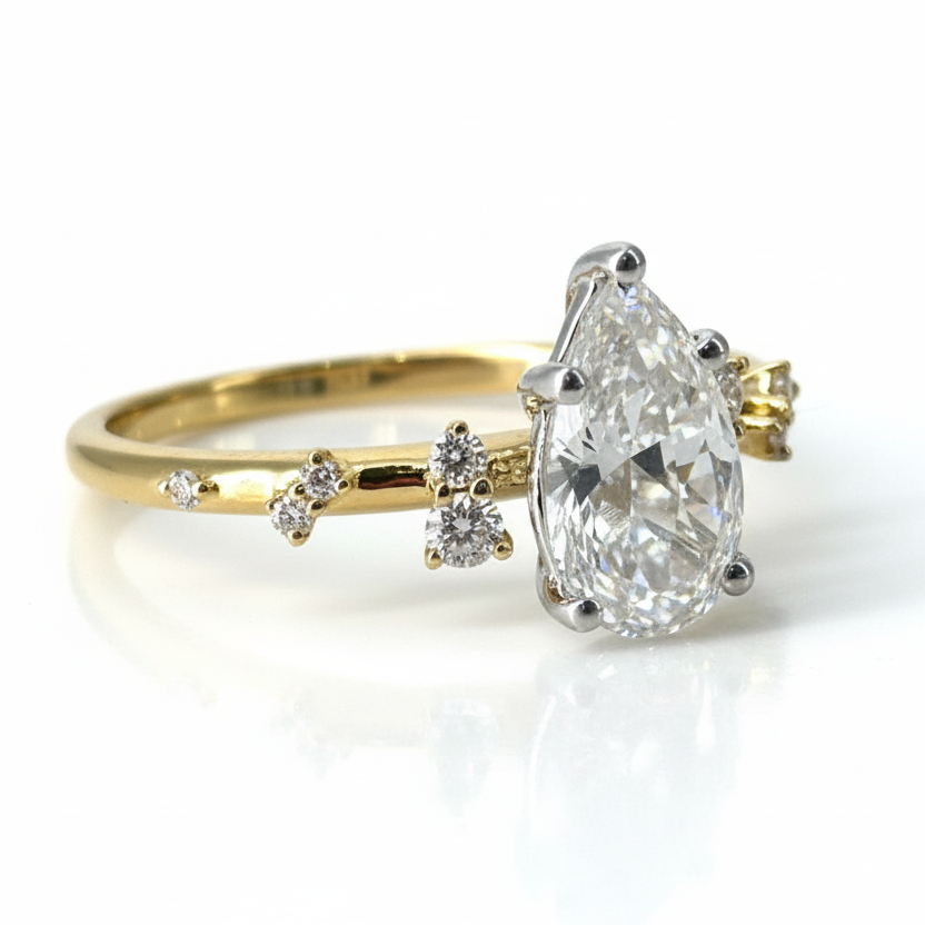 Gold ring with a large diamond and smaller diamonds on a light gray background
