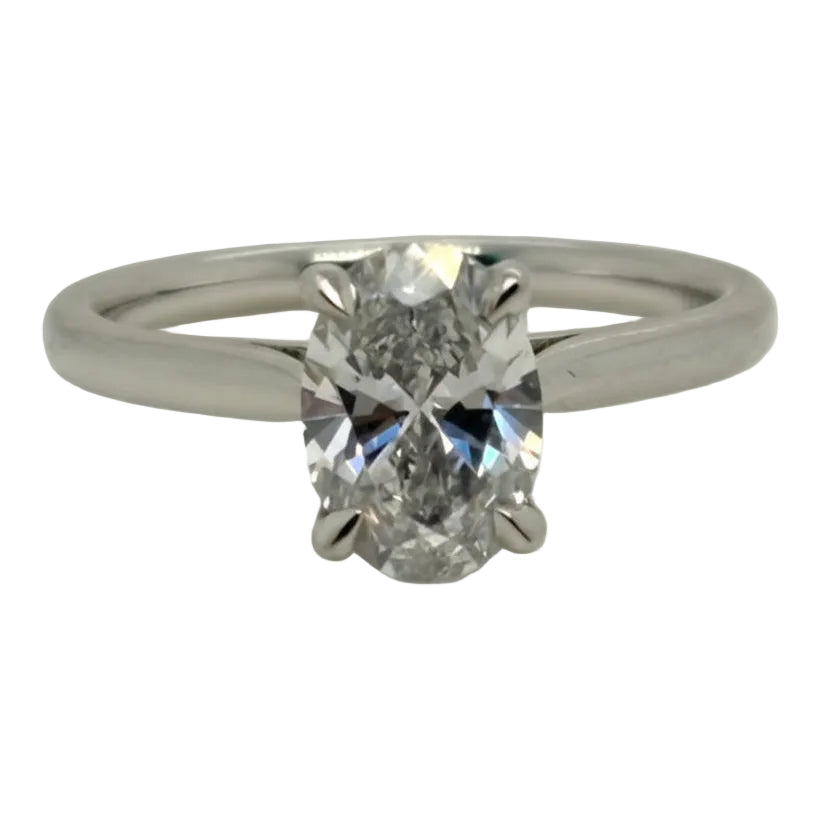 Diamond ring with a white gold band on a light gray background